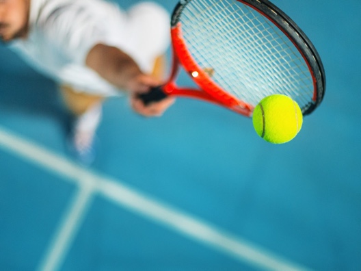 Tennis player serving ball