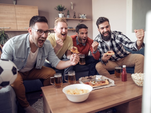 4 men watching sport in lounge room
